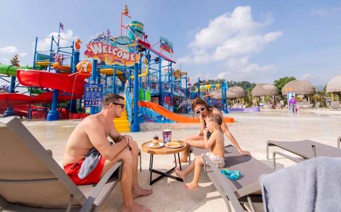 Family relaxing by water slides at Andamanda Phuket Water Park.