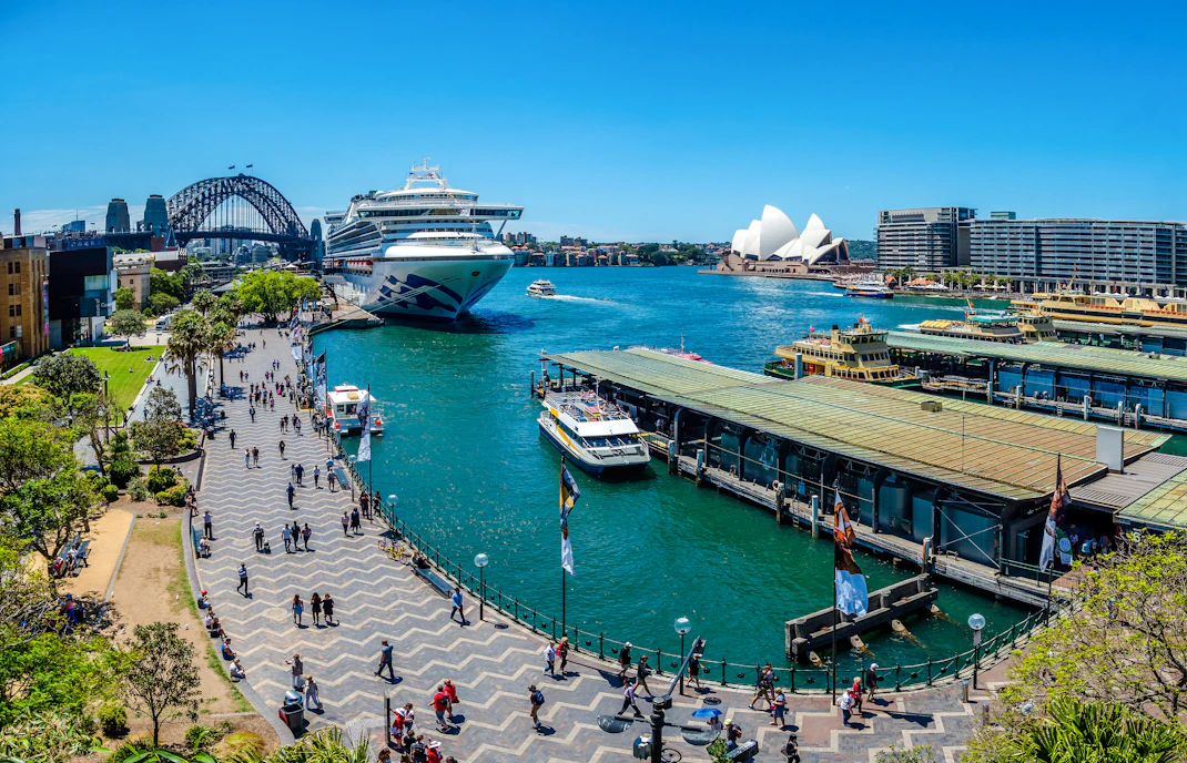 Sydney Harbour view with ferries at Circular Quay, Opera House, and Harbour Bridge in background.