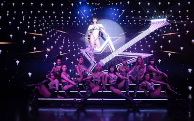 Performers on stage at Calypso Cabaret show in Bangkok with starry backdrop.
