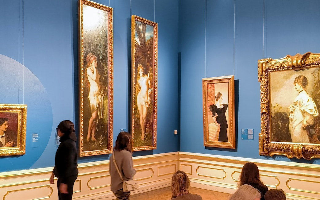 Visitors viewing paintings on a guided tour at Upper Belvedere Palace art gallery.