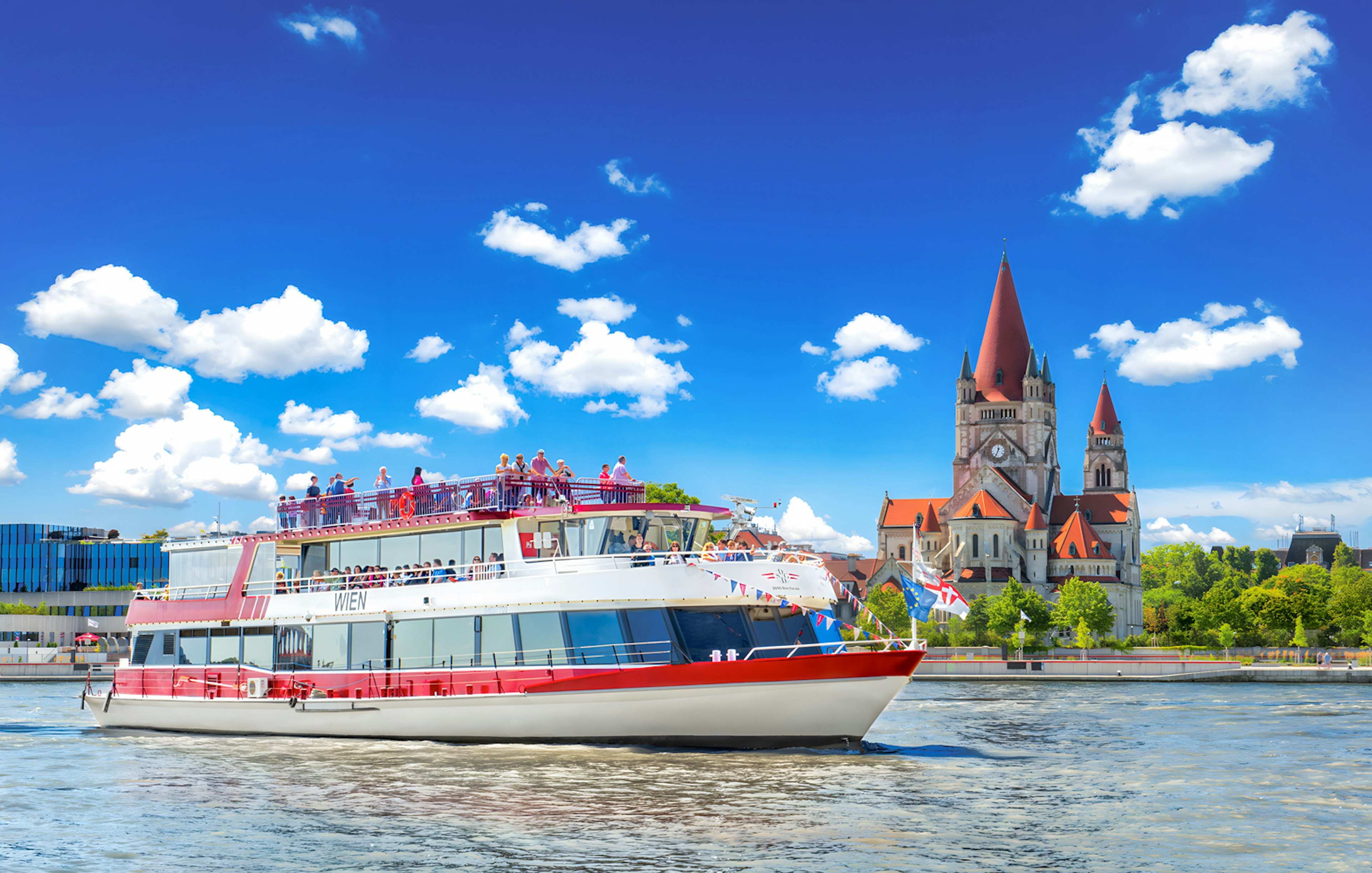 MS Wien ship cruising on the Danube River with St. Francis of Assisi Church in Vienna, Austria.