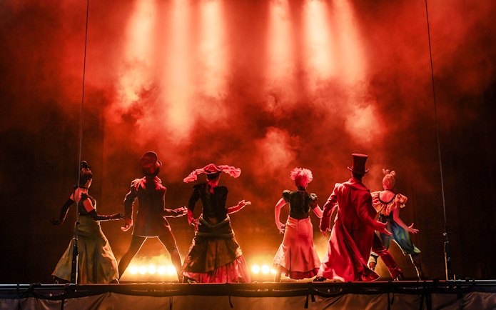 Performers on stage during Moulin Rouge! The Musical in West End, with dramatic lighting.