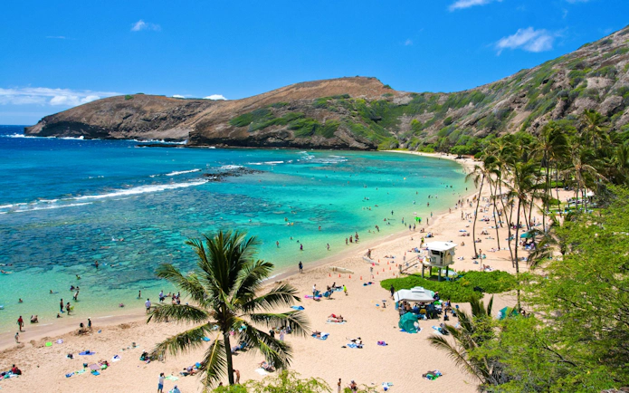 Visitors enjoying the beach and snorkeling in Hanauma Bay, Oahu, Hawaii.