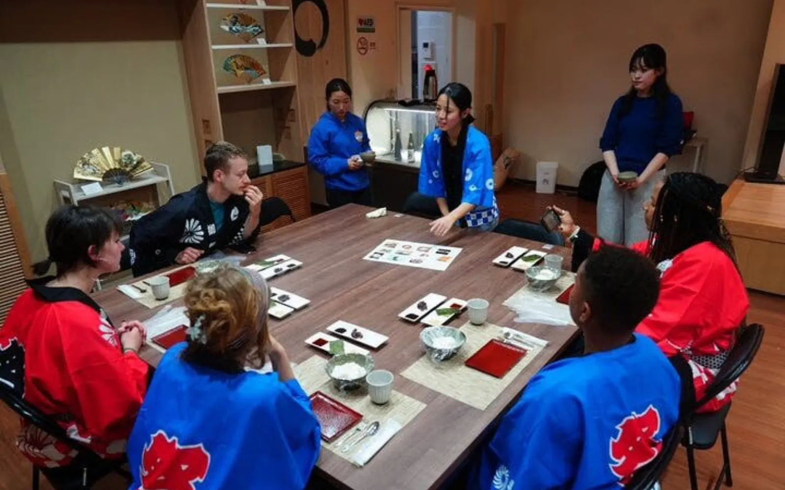 Participants in traditional attire at a Kyoto mochi pounding and tasting experience.