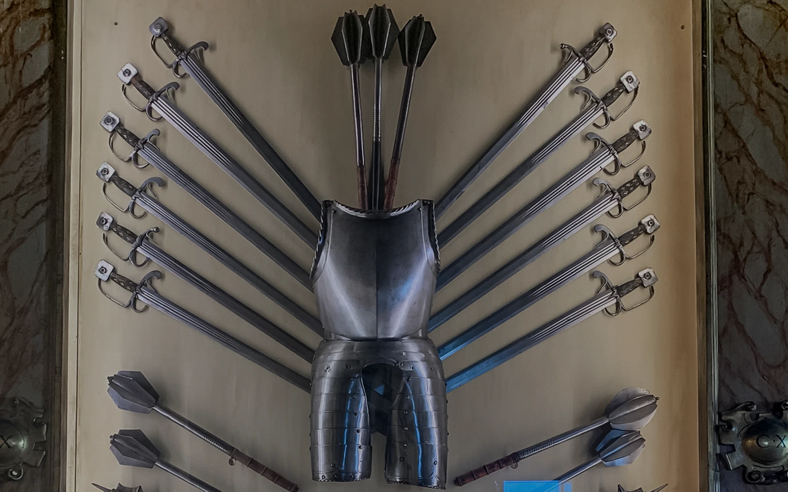 Doge Palace armoury display with swords, maces, and armor in Venice, Italy.