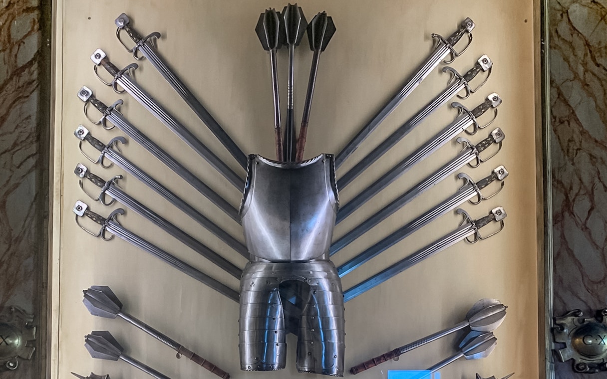 Doge Palace armoury display with swords, maces, and armor in Venice, Italy.