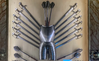 Doge Palace armoury display with swords, maces, and armor in Venice, Italy.