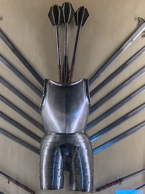 Doge Palace armoury display with swords, maces, and armor in Venice, Italy.