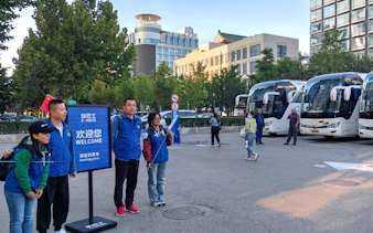 Tour guides and buses at the Mutianyu Great Wall bus tour meeting point in Beijing.