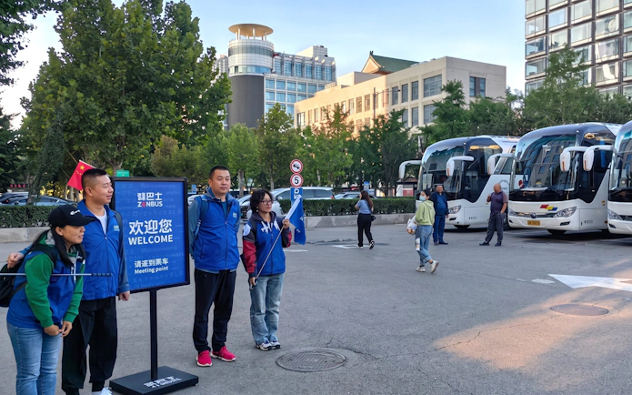 Tour guides and buses at the Mutianyu Great Wall bus tour meeting point in Beijing.