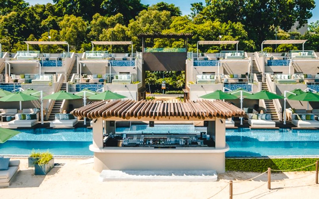 Twelve Beach Club front view with poolside cabanas and bar.