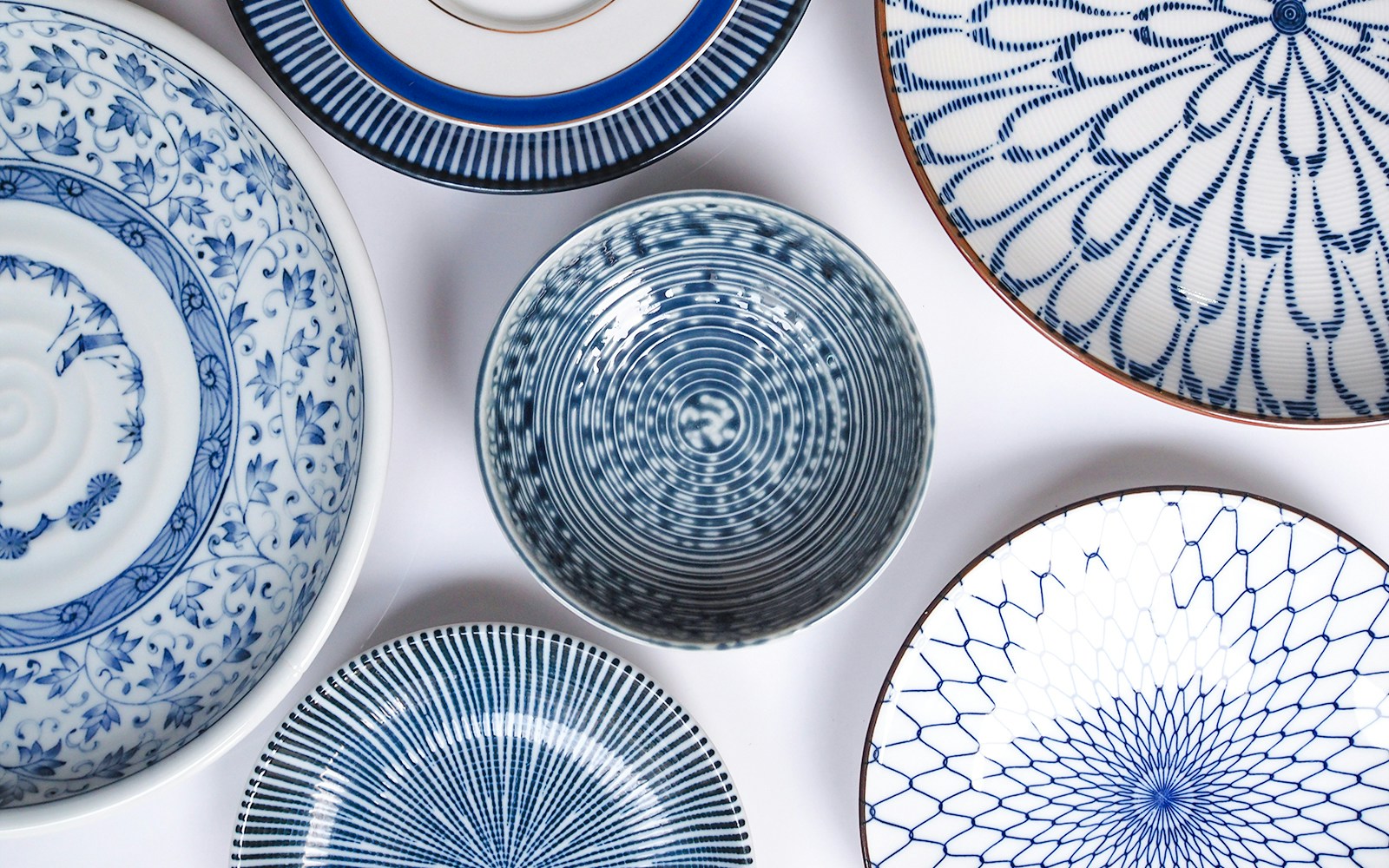 Blue porcelain plates with intricate patterns displayed on a white background.