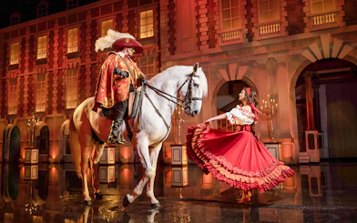 Performer on horseback and dancer in costume at Puy du Fou Theme Park show.