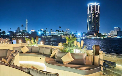 Open-air seating on Nile Dahabiya cruise with Cairo skyline at night.