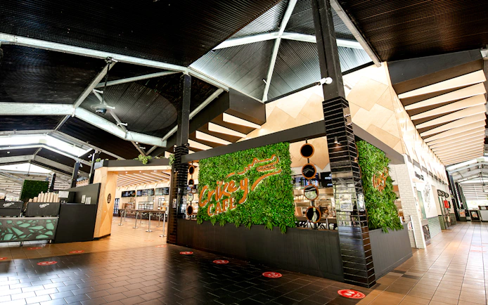 Crikey Cafe entrance at Australia Zoo with green wall decor.
