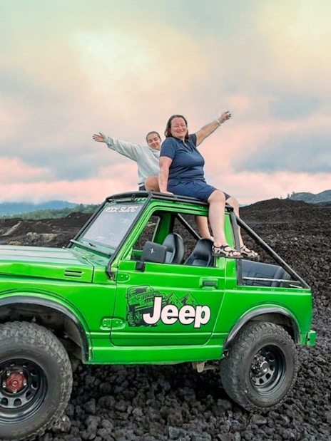 Tourists on a green Jeep during Mount Batur sunrise tour, Bali.
