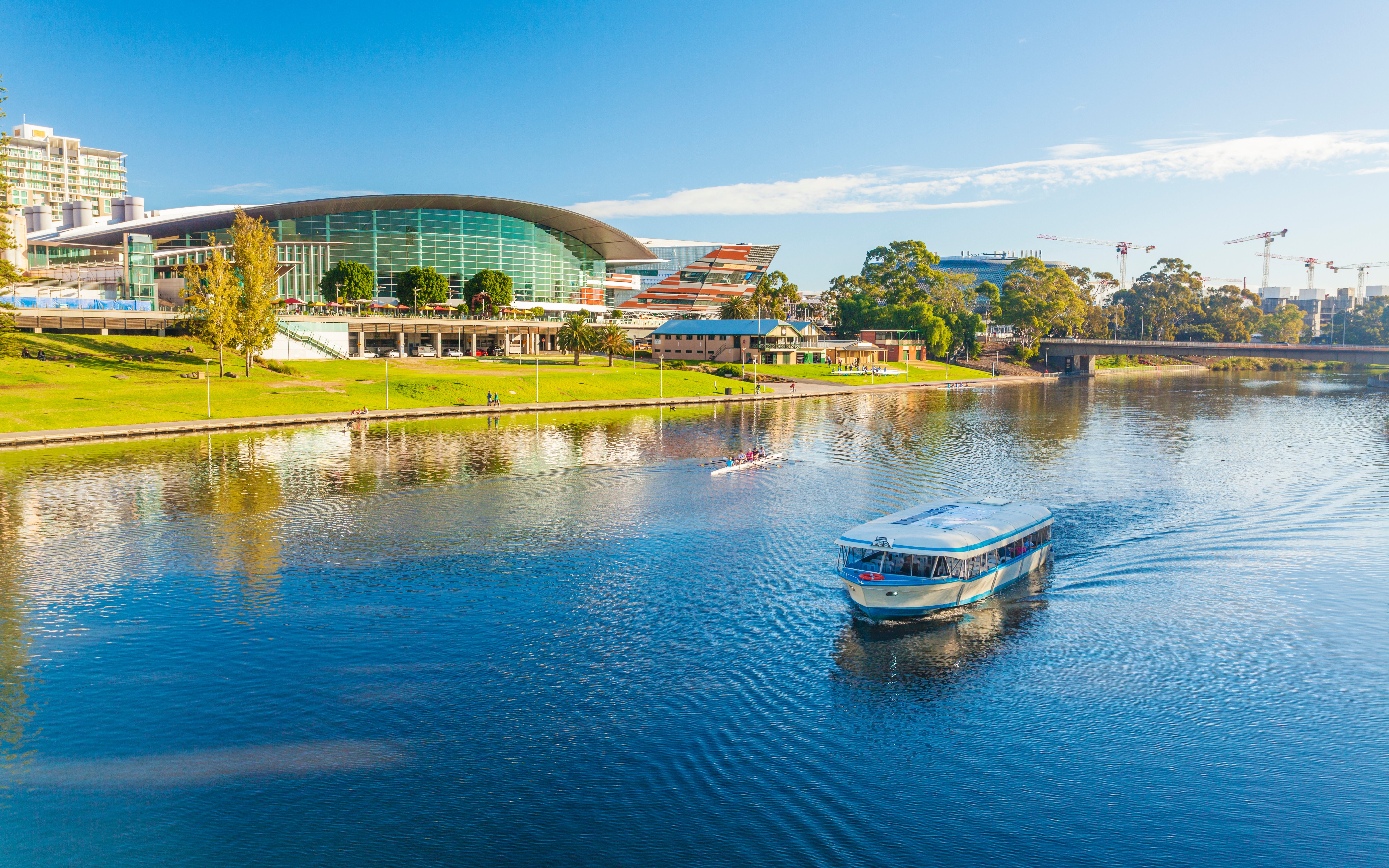 River cruise boat on Adelaide River with cityscape in the background.