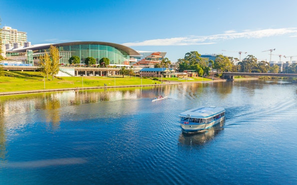 River cruise boat on Adelaide River with cityscape in the background.