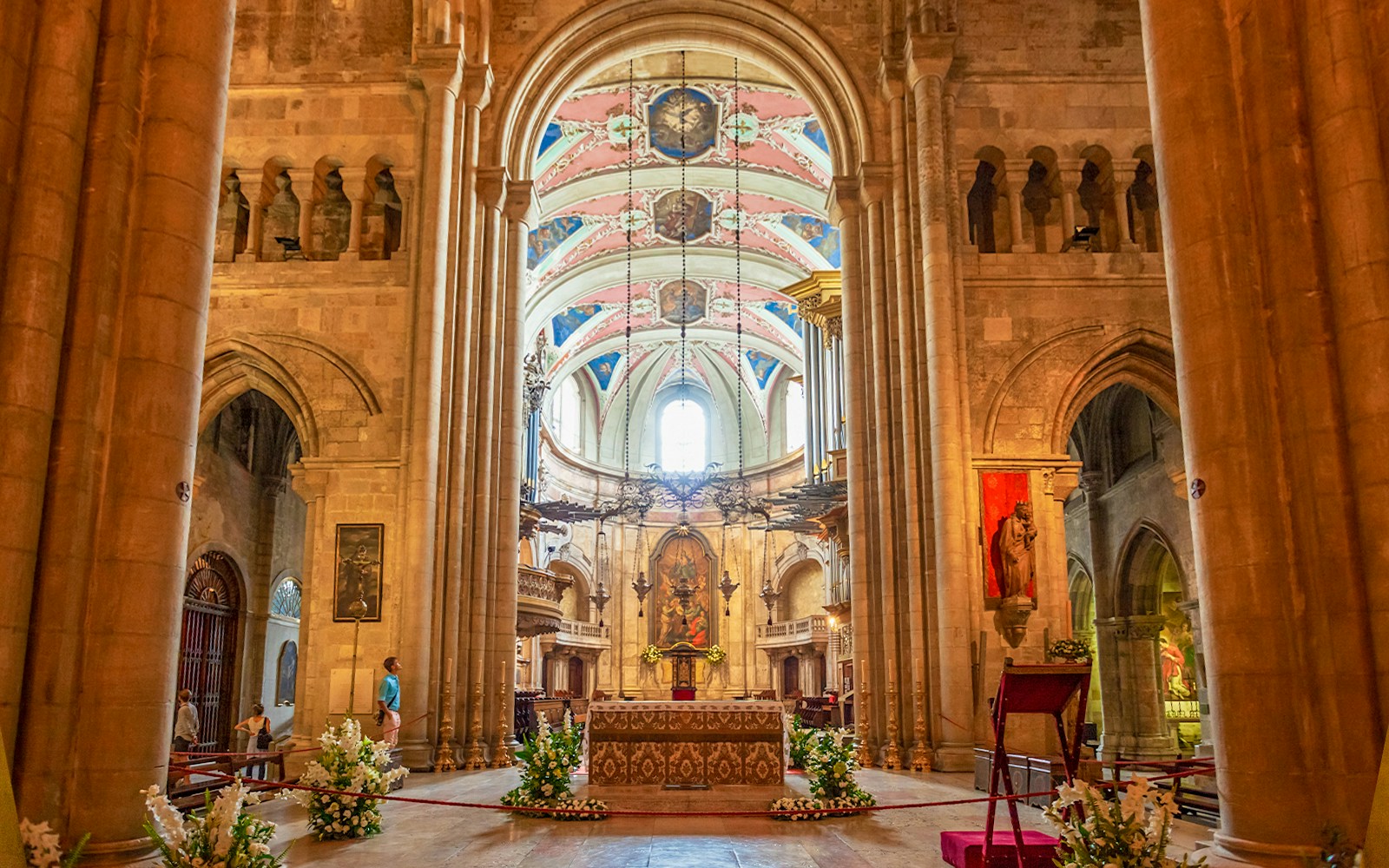 Interior view of Lisbon Cathedral's nave, showcasing ornate arches and historic stone columns.