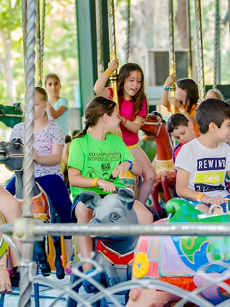 Children enjoying a carousel ride at Parque de Atracciones de Madrid.