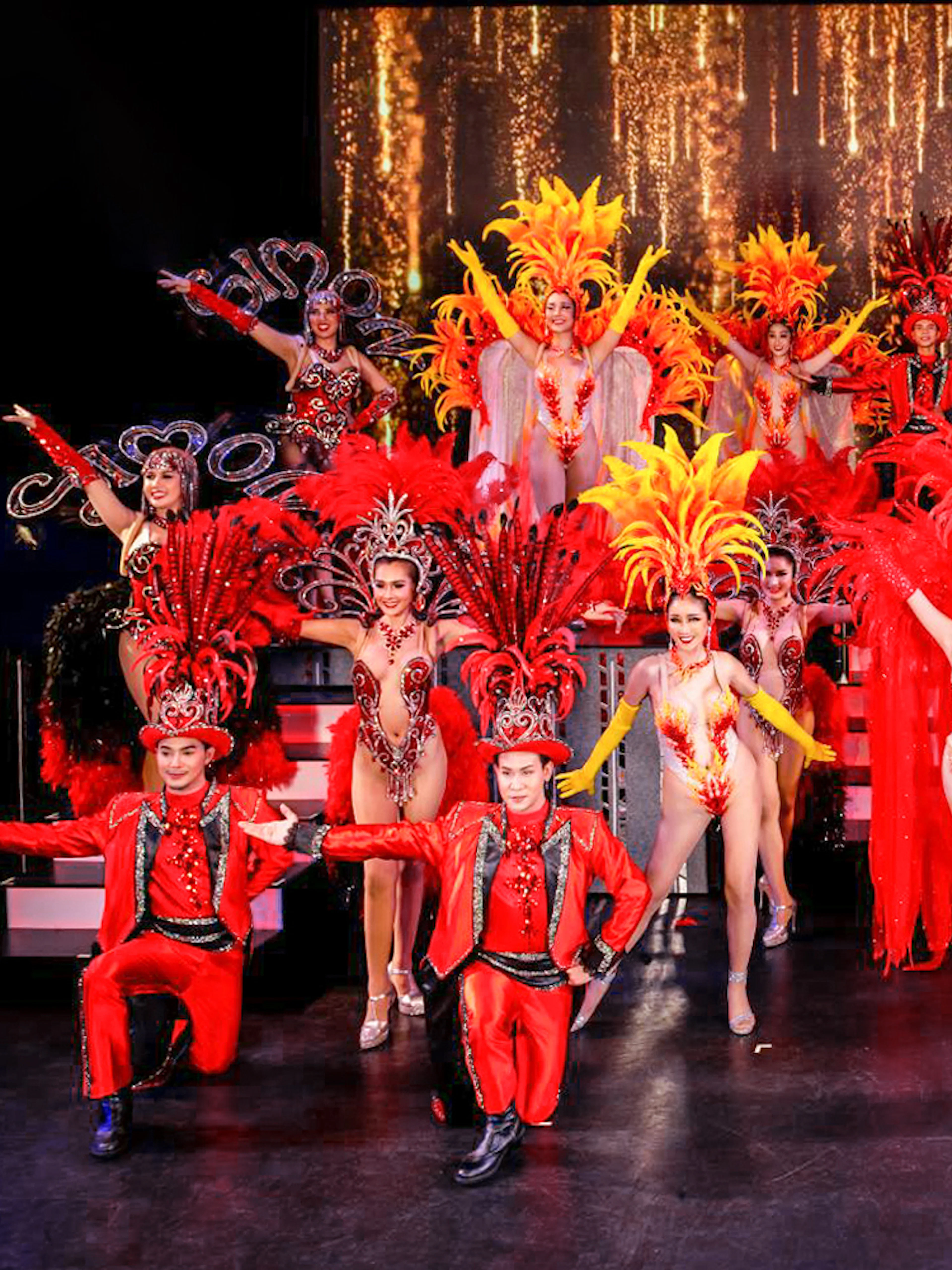 Performers in vibrant costumes on stage at Simon Cabaret Show, Phuket.