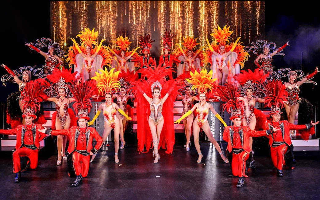 Performers in vibrant costumes on stage at Simon Cabaret Show, Phuket.
