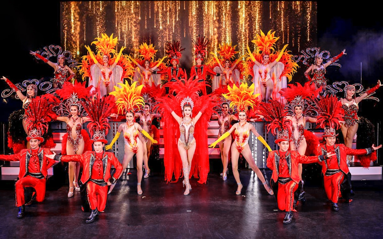 Performers in vibrant costumes on stage at Simon Cabaret Show, Phuket.