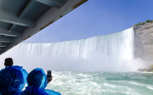 Visitors in blue ponchos on a boat tour near Niagara Falls, USA.