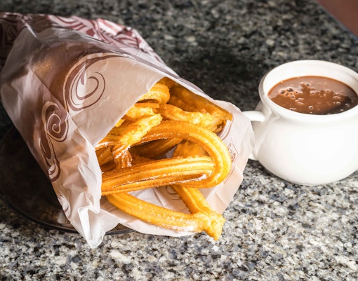 Churros with hot chocolate on a table in Madrid.