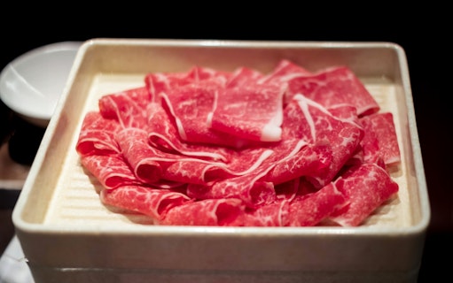 Sliced beef arranged on a tray for a culinary experience.