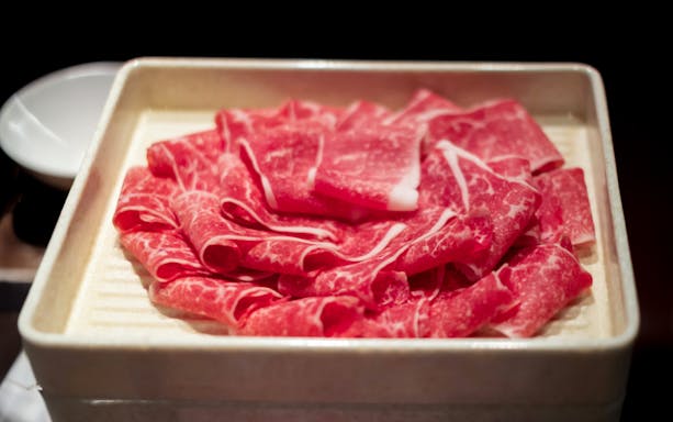 Sliced beef arranged on a tray for a culinary experience.