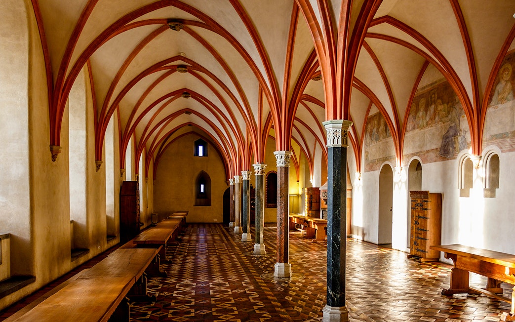 Malbork Castle interior with vaulted ceilings and medieval decor.