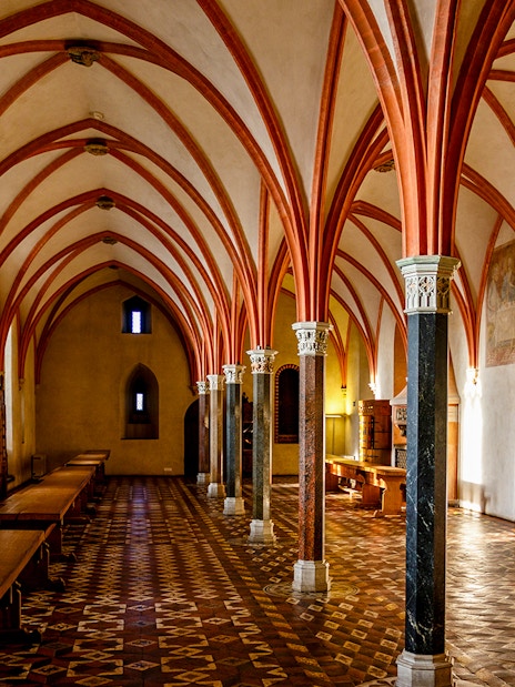 Malbork Castle interior with vaulted ceilings and medieval decor.