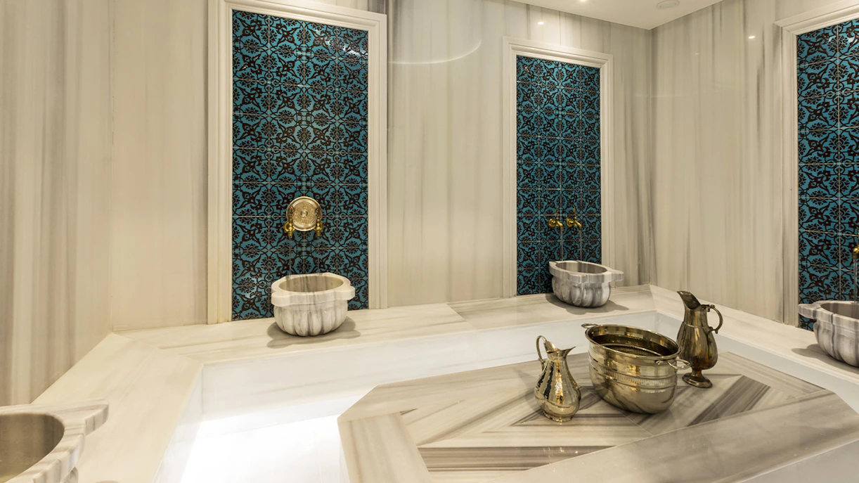 Turkish bath interior with marble basin and towel in Taksim, Istanbul, showcasing spa experience.