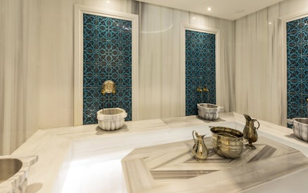 Turkish bath interior with marble basin and towel in Taksim, Istanbul, showcasing spa experience.