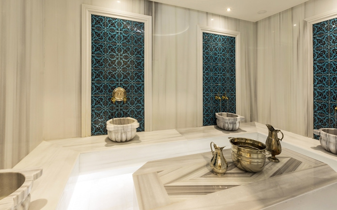Turkish bath interior with marble basin and towel in Taksim, Istanbul, showcasing spa experience.