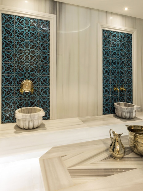 Turkish bath interior with marble basin and towel in Taksim, Istanbul, showcasing spa experience.