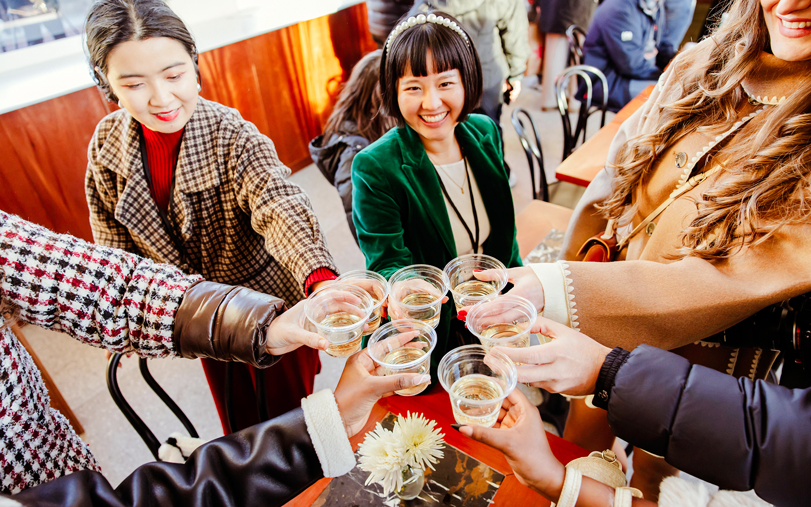 Group toasting with drinks at Rockefeller Center holiday event.