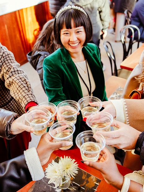 Group toasting with drinks at Rockefeller Center holiday event.