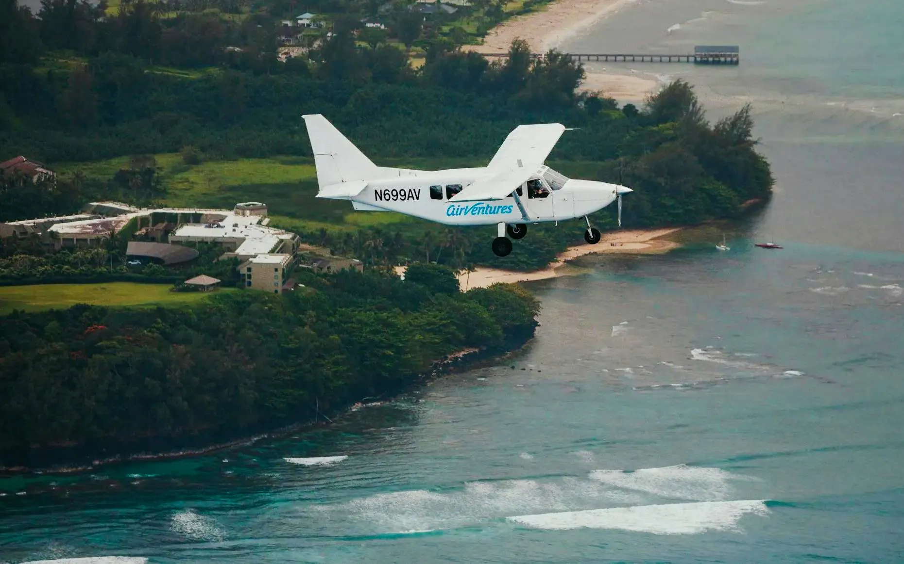 Small plane flying over Kauai coastline during private air tour.