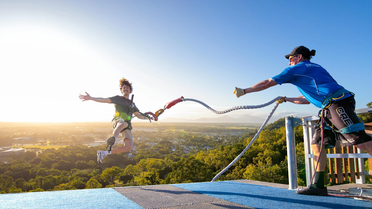 Visitor bungee jumping from Skypark Cairns roof at sunrise.