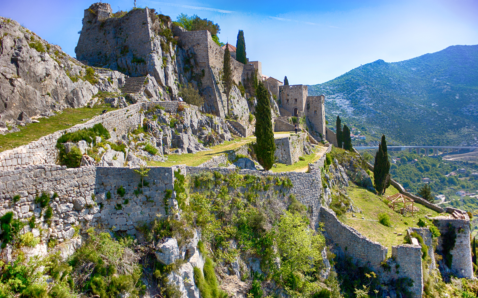 Klis Fortress stone walls and towers on a hillside in Croatia.