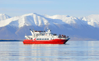 Whale watching boat in Akureyri with snowy mountains in the background.
