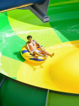 Person enjoying water slide at Gamuda Cove water park.