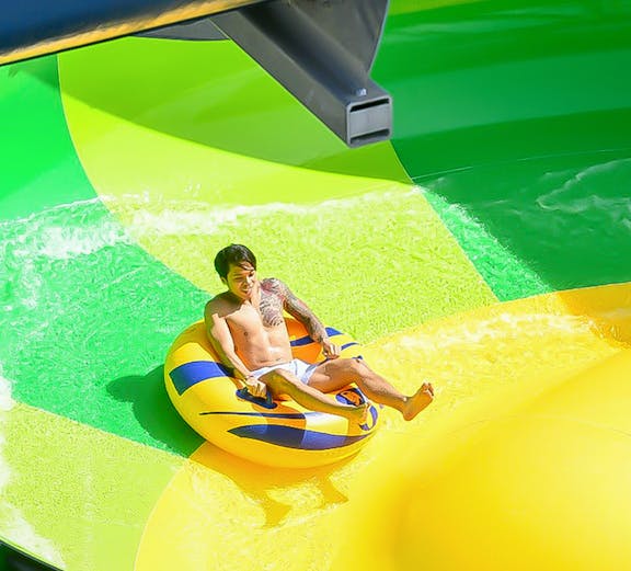 Person enjoying water slide at Gamuda Cove water park.