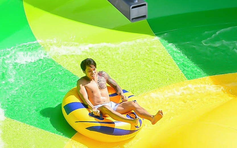 Person enjoying water slide at Gamuda Cove water park.