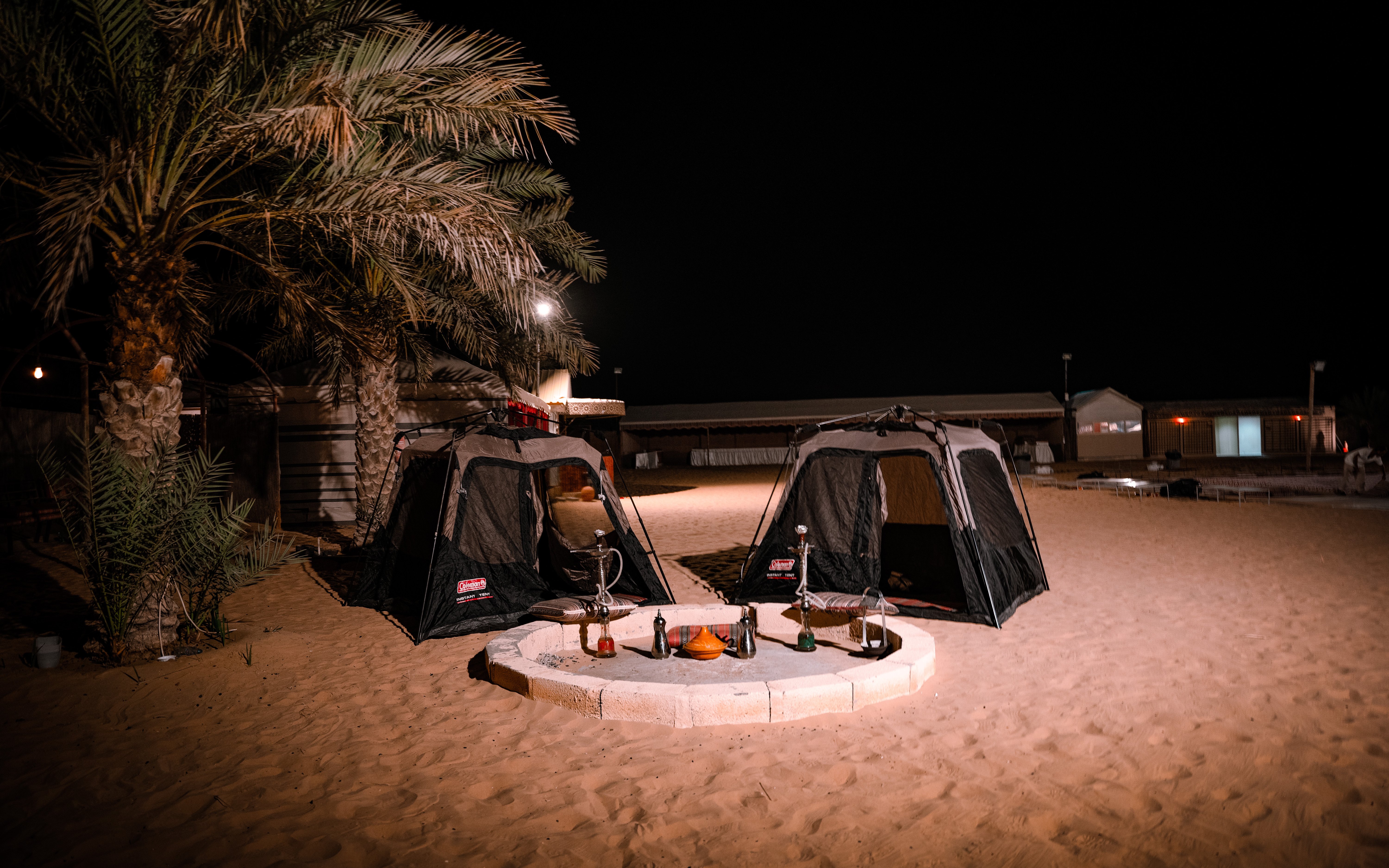 Tents set up for overnight stay at desert safari, Abu Dhabi, with a campfire area.