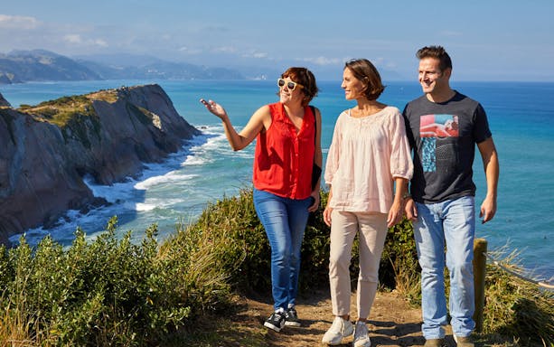 Tourists walking along the coastal cliffs of Zumaia during a guided tour from San Sebastian.