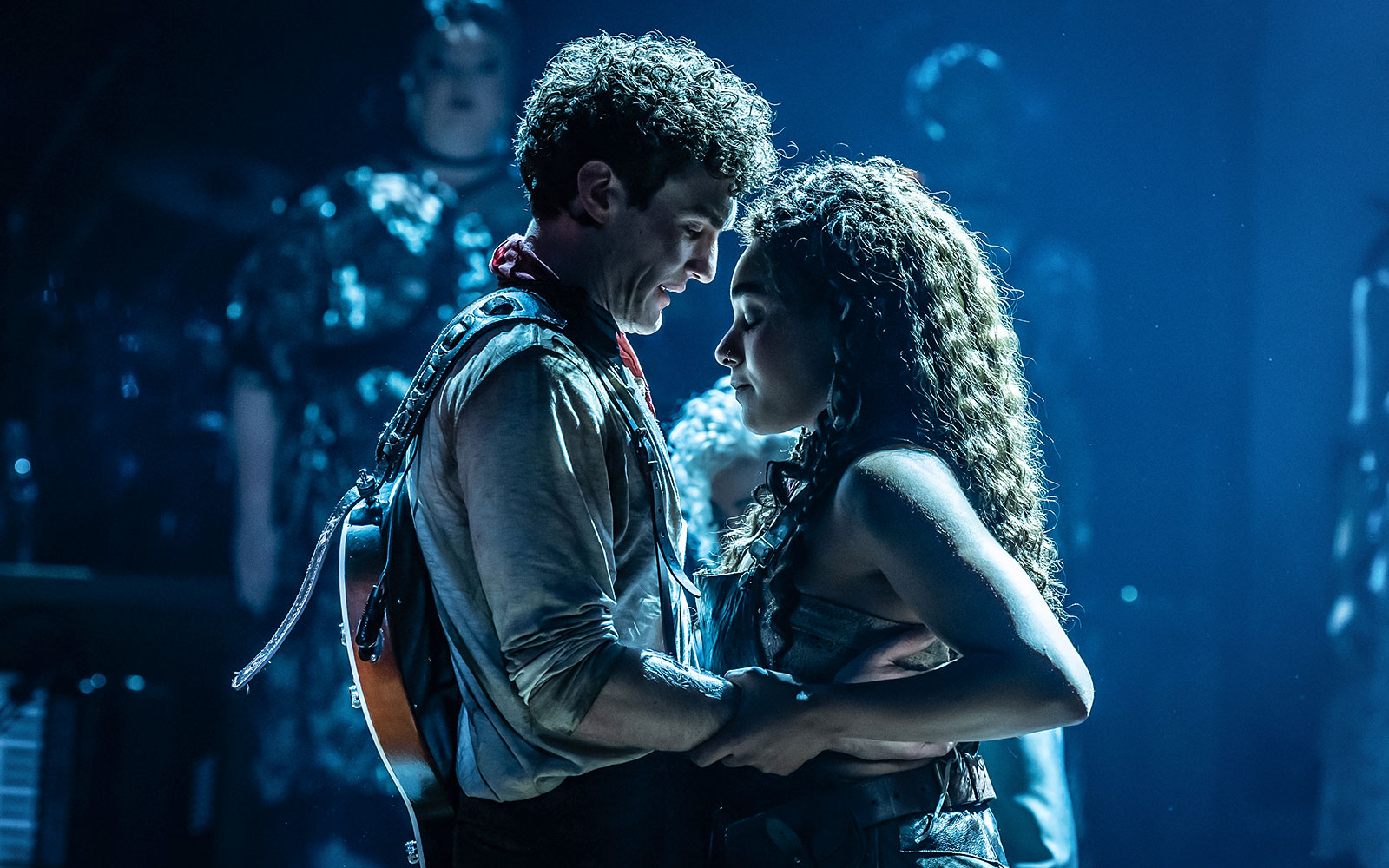 Performers embracing on stage during Hadestown musical.