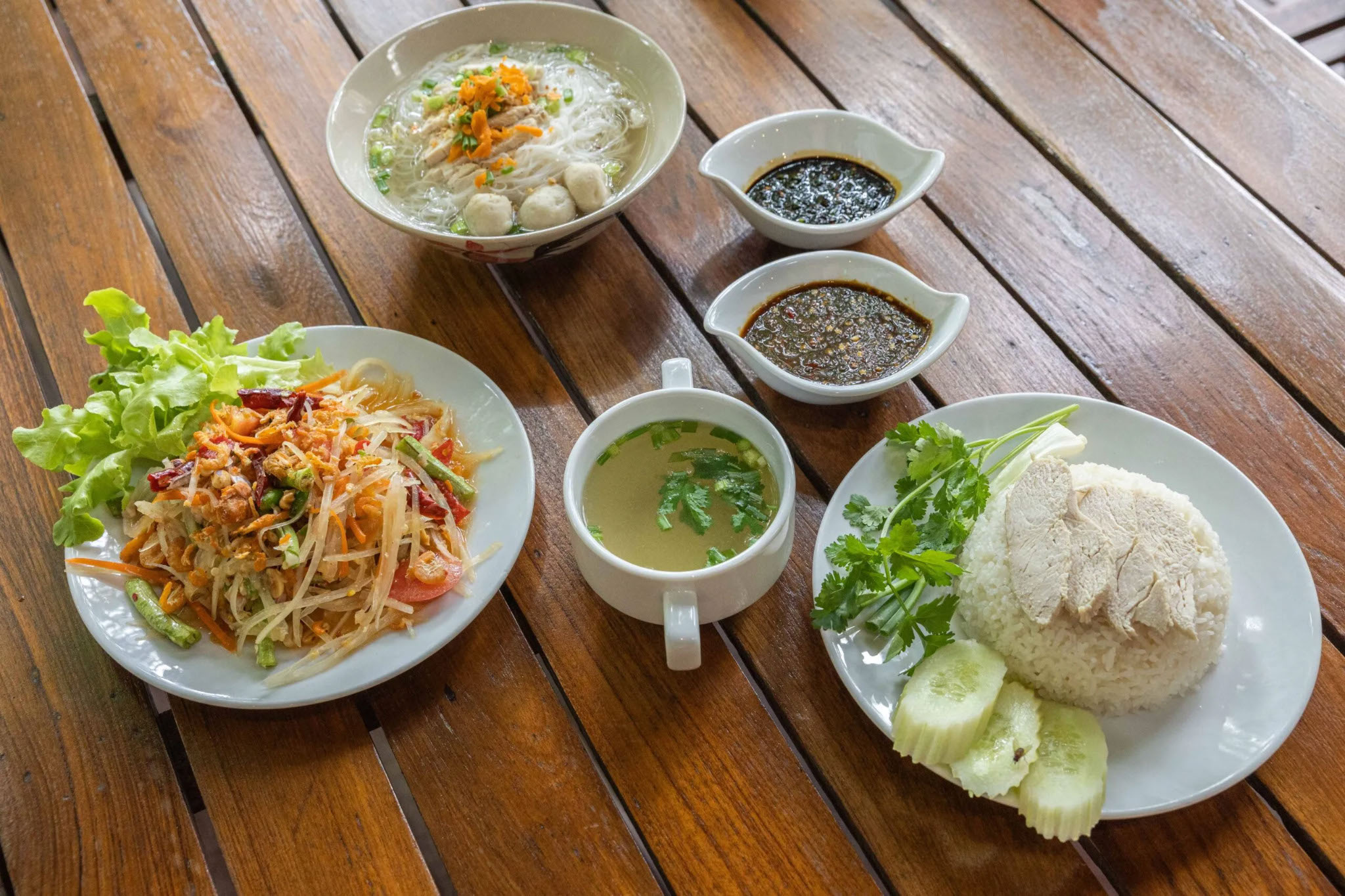 Traditional Thai dishes at Hanuman World buffet, featuring papaya salad, noodle soup, and chicken rice.